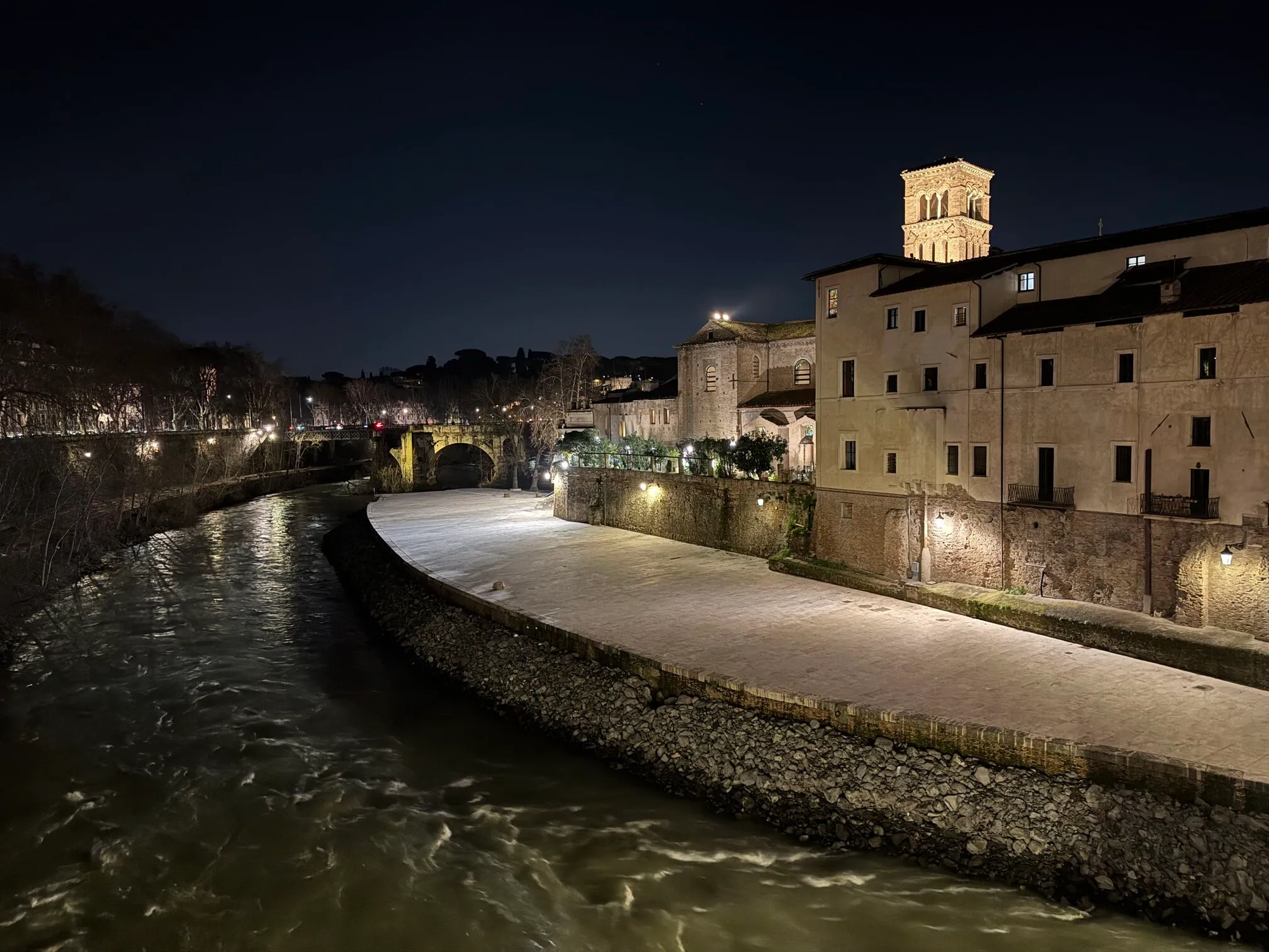 Elven tiber som renner ved siden av et gammelt bygg