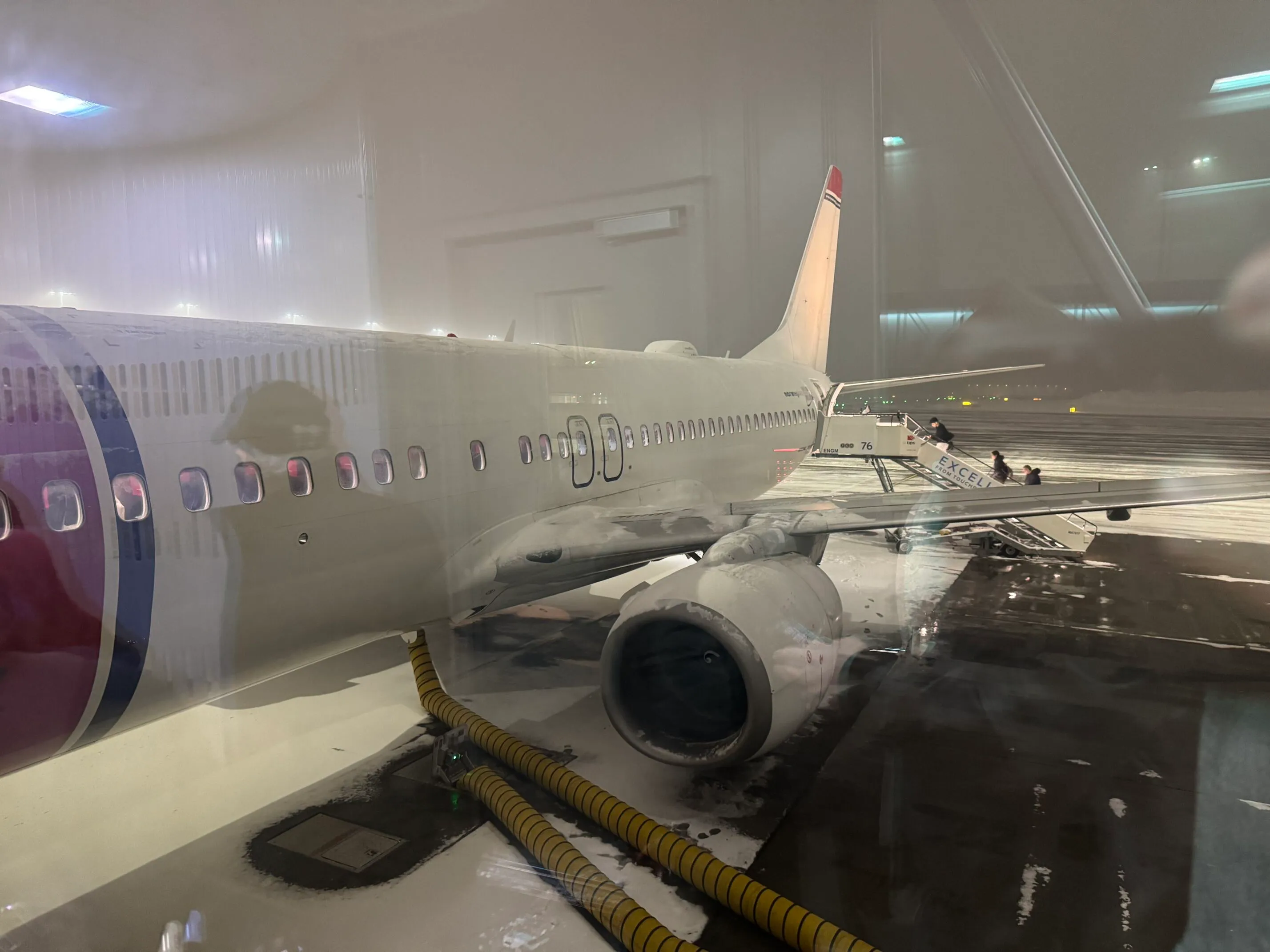 Norwegian fly parkert på Oslo Gardemoen i vintervær